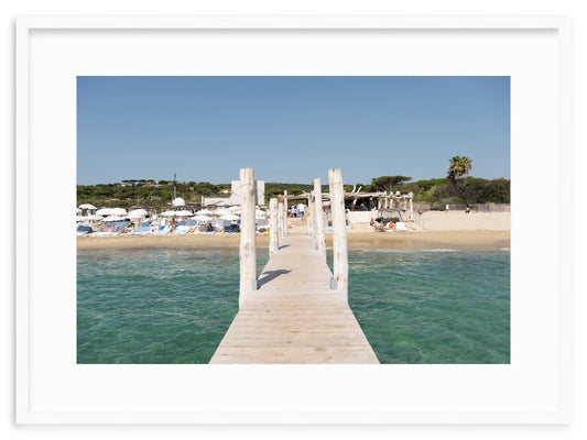 A framed fine art photograph of the legendary dock at Club 55, on Pampelonne plage, Ramatuelle, Saint-Tropez in the summer. 